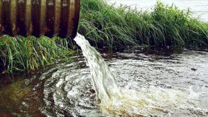 Wasser fließt aus einem Rohr in ein Gewässer